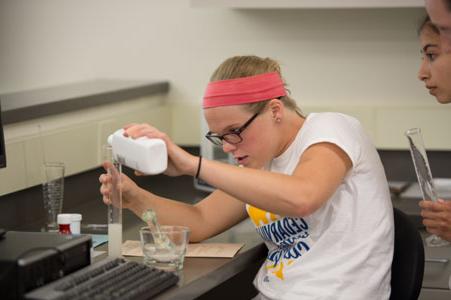 A student pours liquid in to a flask