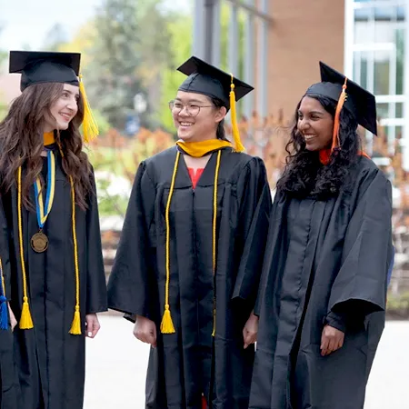 三个穿着毕业礼服微笑的大学生.