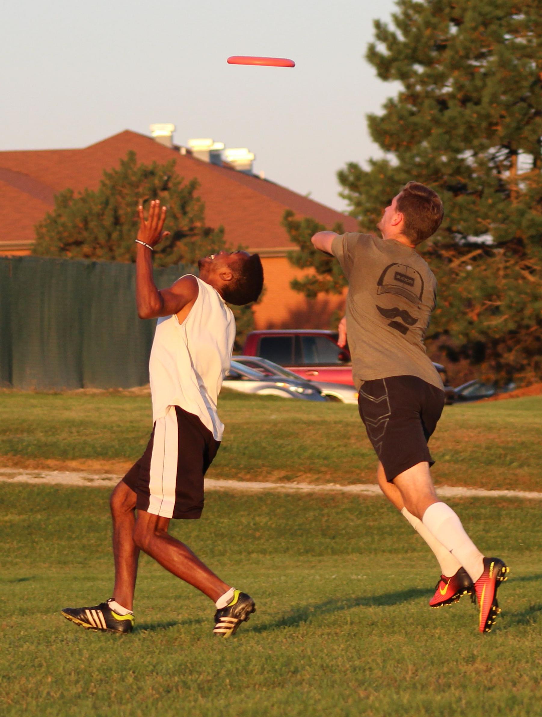 Two students catch an ultimate frisbee